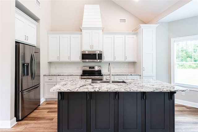 119 Silver Bluff Dr, Brunswick, GA 31523 - kitchen with stainless steel appliances, backsplash, light wood-style floors, white cabinets, and high vaulted ceiling