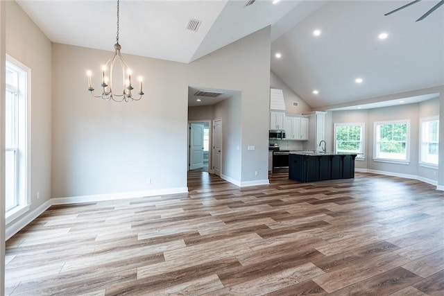 119 Silver Bluff Dr, Brunswick, GA 31523 - unfurnished living room with a chandelier, wood finished floors, high vaulted ceiling, and recessed lighting