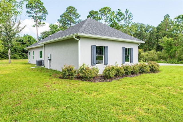 119 Silver Bluff Dr, Brunswick, GA 31523 - view of side of home featuring stucco siding, a yard, and a shingled roof