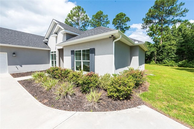 119 Silver Bluff Dr, Brunswick, GA 31523 - view of home's exterior featuring stucco siding, a yard, and a shingled roof
