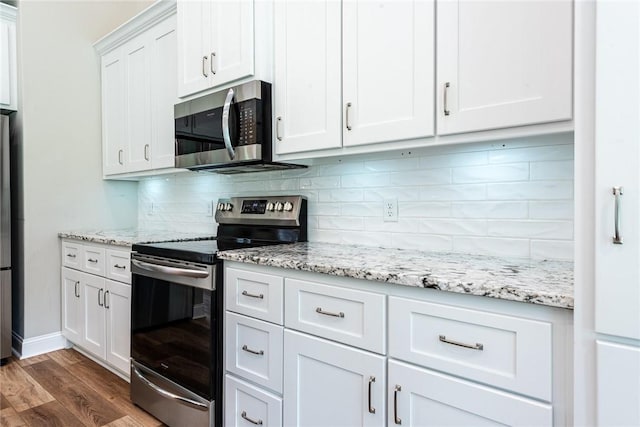 119 Silver Bluff Dr, Brunswick, GA 31523 - kitchen with appliances with stainless steel finishes, dark wood-type flooring, decorative backsplash, white cabinets, and light stone countertops