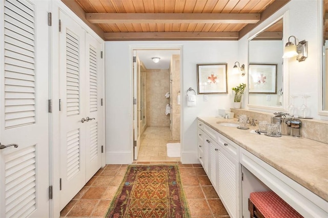 bathroom featuring a tile shower, vanity, beamed ceiling, and wood ceiling