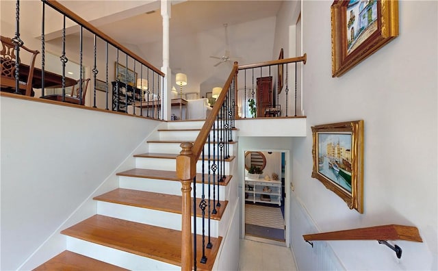 stairs featuring ceiling fan