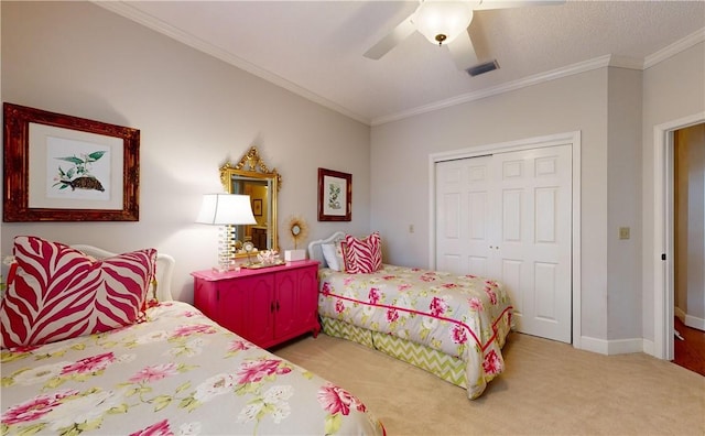 carpeted bedroom with ceiling fan, a closet, and ornamental molding