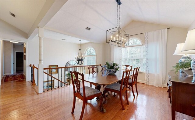 dining room featuring hardwood / wood-style floors, lofted ceiling, and a chandelier