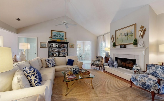 living room featuring ceiling fan, a fireplace, vaulted ceiling, and hardwood / wood-style flooring