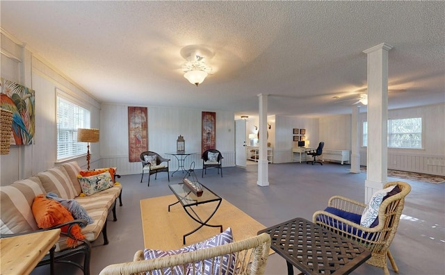 living room with ceiling fan and a textured ceiling