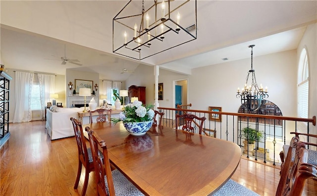 dining room featuring ceiling fan, vaulted ceiling, and light wood-type flooring