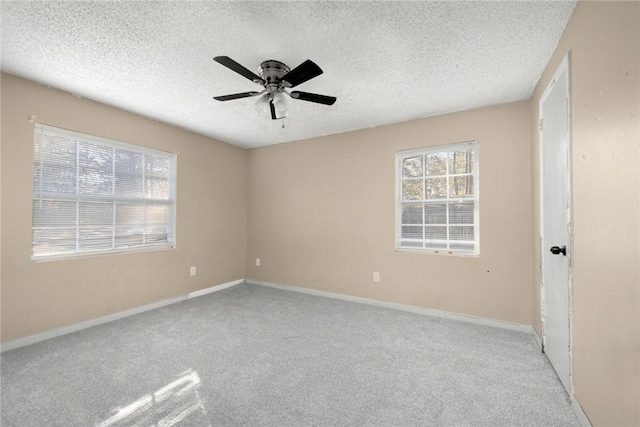 carpeted spare room with ceiling fan and a textured ceiling