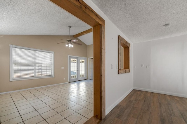 tiled spare room with french doors, ceiling fan, a textured ceiling, and vaulted ceiling with beams