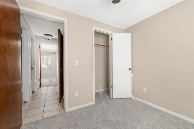 unfurnished bedroom featuring light colored carpet, a closet, and a textured ceiling