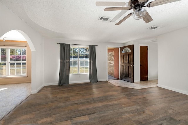 spare room with hardwood / wood-style floors, a textured ceiling, and a wealth of natural light