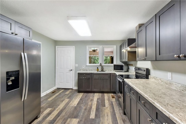 1069 Shellman Hammock Dr NE, Townsend, GA 31331 - kitchen with appliances with stainless steel finishes, a sink, dark wood finished floors, wall chimney range hood, and baseboards