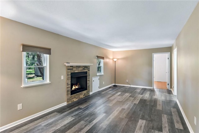 1069 Shellman Hammock Dr NE, Townsend, GA 31331 - unfurnished living room featuring healthy amount of natural light, a fireplace, dark wood-style flooring, and baseboards