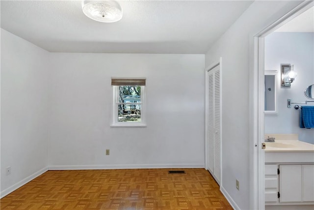 1069 Shellman Hammock Dr NE, Townsend, GA 31331 - unfurnished bedroom with a closet, baseboards, ensuite bath, and a sink
