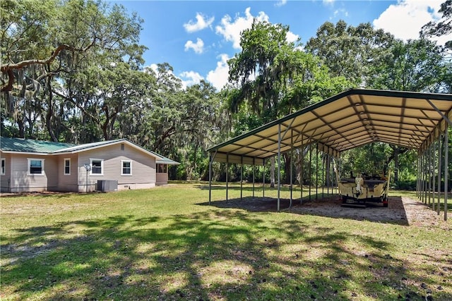1069 Shellman Hammock Dr NE, Townsend, GA 31331 - view of green lawn featuring a detached carport, central air condition unit, and view of wooded area