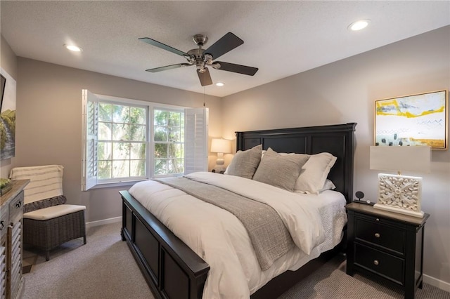 bedroom featuring ceiling fan, light carpet, and a textured ceiling