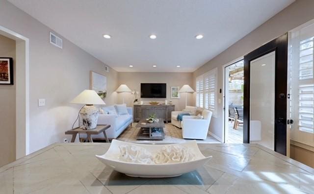 living area with recessed lighting, visible vents, and plenty of natural light