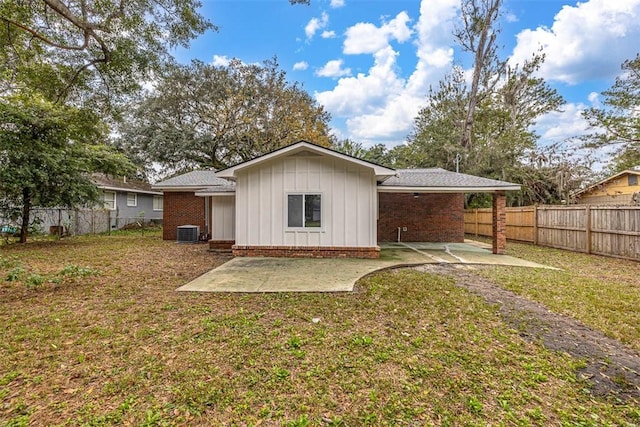 back of house with central AC unit, a patio area, and a yard