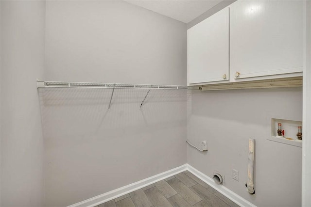 laundry area with cabinets, hookup for an electric dryer, gas dryer hookup, hookup for a washing machine, and wood-type flooring