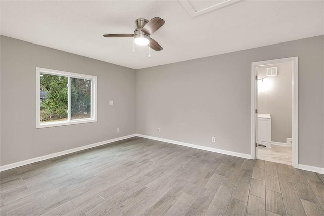 unfurnished bedroom featuring ceiling fan, light wood-type flooring, and ensuite bath