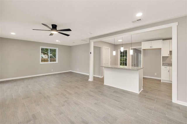 unfurnished living room featuring light hardwood / wood-style floors and ceiling fan