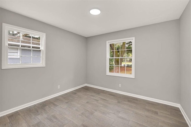 empty room with light hardwood / wood-style floors and a healthy amount of sunlight