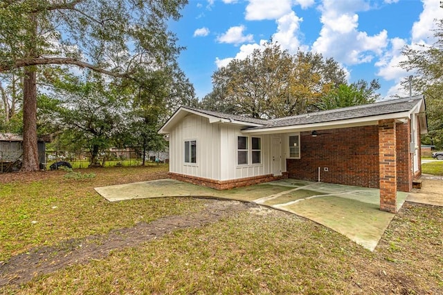 back of house with a lawn and a patio