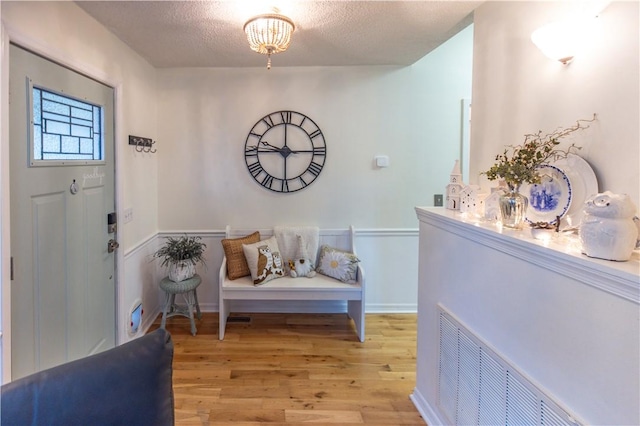 entryway featuring light wood-type flooring and a textured ceiling