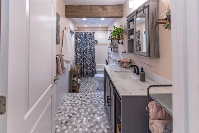 bathroom featuring toilet, walk in shower, beam ceiling, and vanity