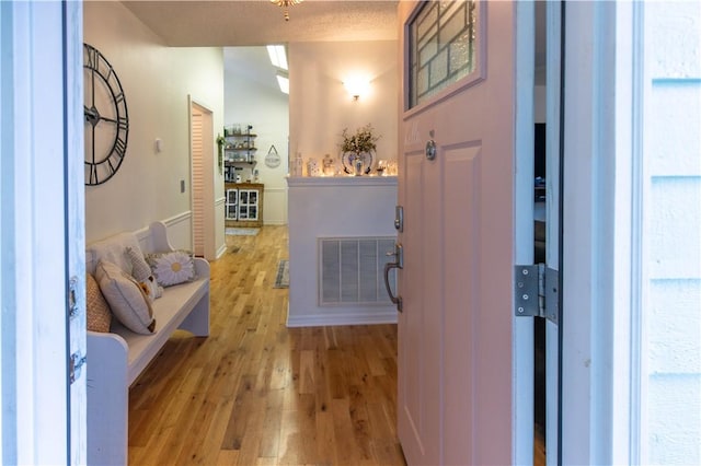 interior space featuring a textured ceiling and light hardwood / wood-style flooring