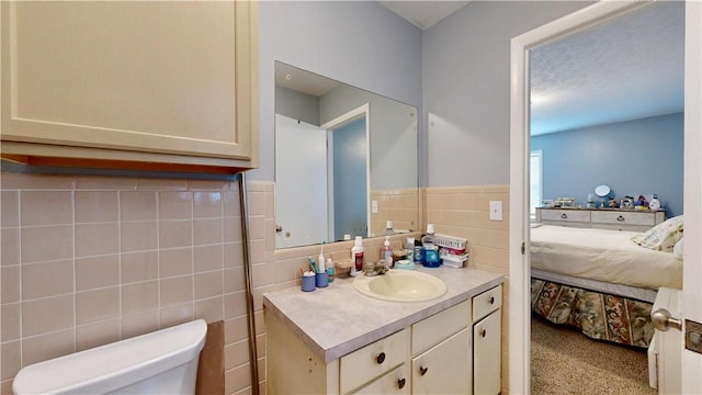 1703 Rainbow Dr, Waycross, GA 31501 - bathroom featuring vanity, ensuite bathroom, tile walls, and wainscoting
