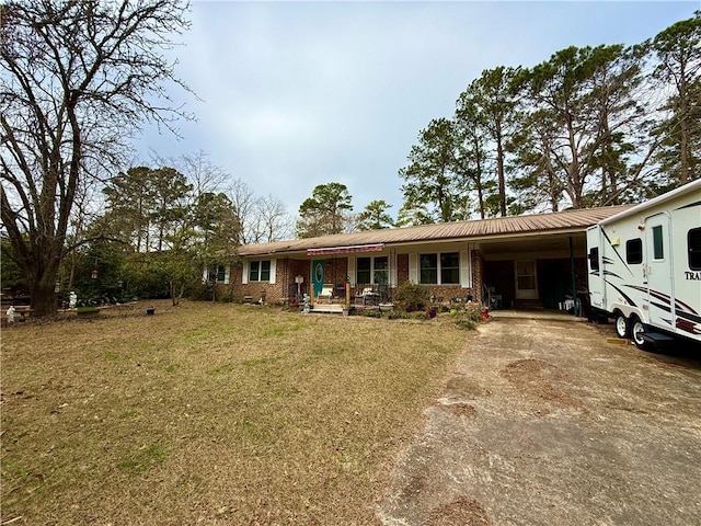 1703 Rainbow Dr, Waycross, GA 31501 - view of front of house featuring a carport, covered porch, driveway, a front lawn, and a metal roof