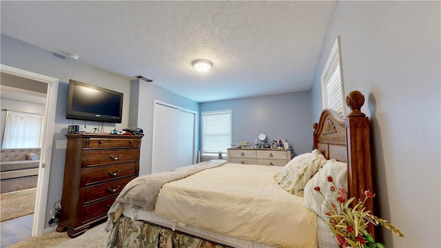 1703 Rainbow Dr, Waycross, GA 31501 - carpeted bedroom with a textured ceiling and a closet