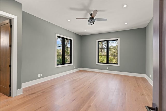 spare room with ceiling fan, plenty of natural light, and light hardwood / wood-style flooring