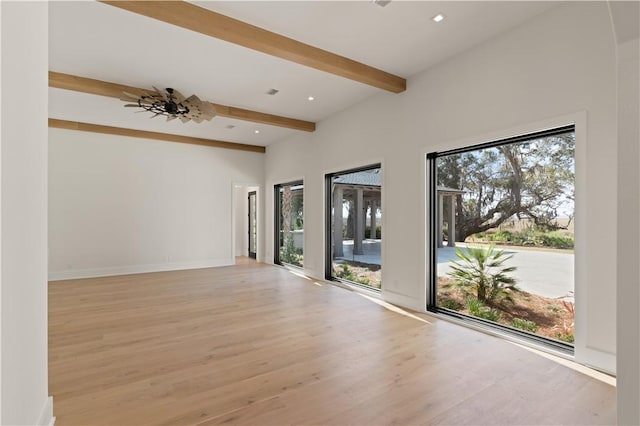 spare room featuring beam ceiling, light hardwood / wood-style flooring, and ceiling fan