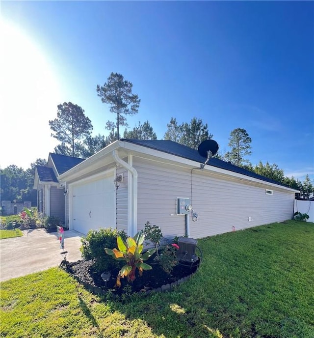 10003 Woodland Cv, Brunswick, GA 31525 - view of side of property featuring concrete driveway, a lawn, and a garage