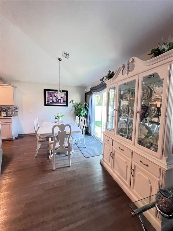 10003 Woodland Cv, Brunswick, GA 31525 - dining area with lofted ceiling, dark wood-style floors, and a chandelier