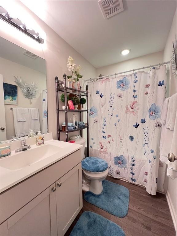 10003 Woodland Cv, Brunswick, GA 31525 - bathroom featuring vanity, wood finished floors, and a shower with curtain