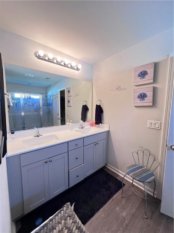 10003 Woodland Cv, Brunswick, GA 31525 - bathroom featuring double vanity, wood finished floors, and a shower stall