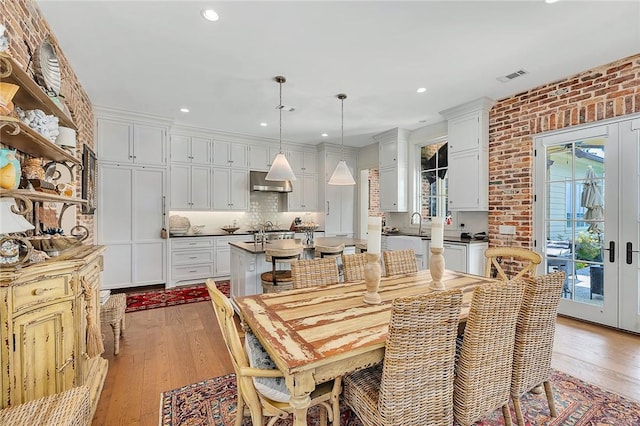 dining room with light hardwood / wood-style floors, sink, and a wealth of natural light