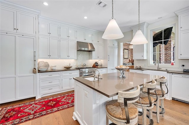 kitchen with white cabinetry, an island with sink, white dishwasher, stainless steel stove, and light wood-type flooring