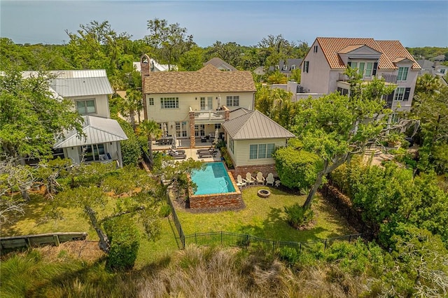 rear view of property featuring a balcony, a fenced in pool, and a patio