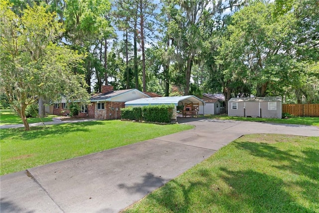 165 Pine Cir, Brunswick, GA 31520 - ranch-style house with a storage shed, a detached carport, a chimney, concrete driveway, and view of scattered trees