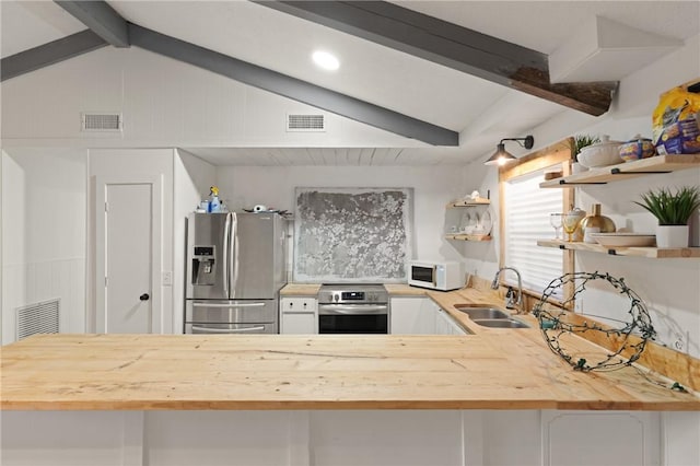 165 Pine Cir, Brunswick, GA 31520 - kitchen featuring oven, stainless steel fridge with ice dispenser, white microwave, open shelves, and butcher block counters