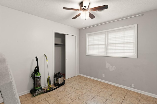 165 Pine Cir, Brunswick, GA 31520 - unfurnished bedroom featuring a closet, a textured ceiling, ceiling fan, and light tile patterned floors
