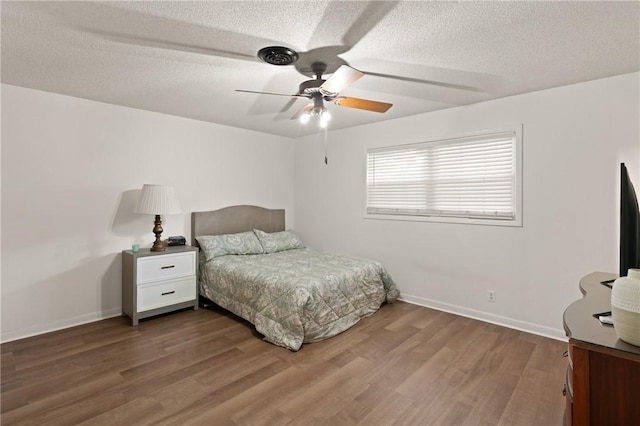 165 Pine Cir, Brunswick, GA 31520 - bedroom featuring dark wood-style floors, a textured ceiling, and a ceiling fan