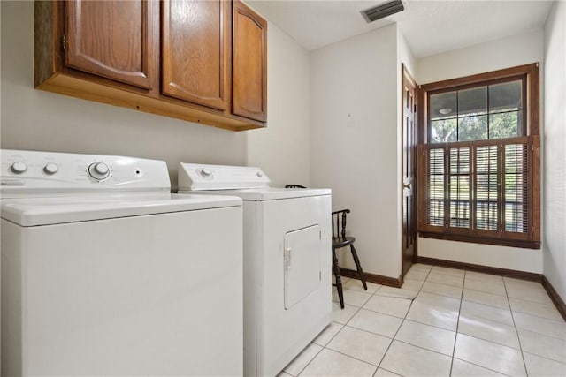 laundry room with light tile patterned floors, cabinets, and independent washer and dryer