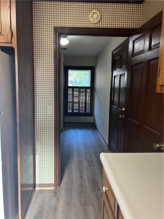 corridor with dark hardwood / wood-style flooring