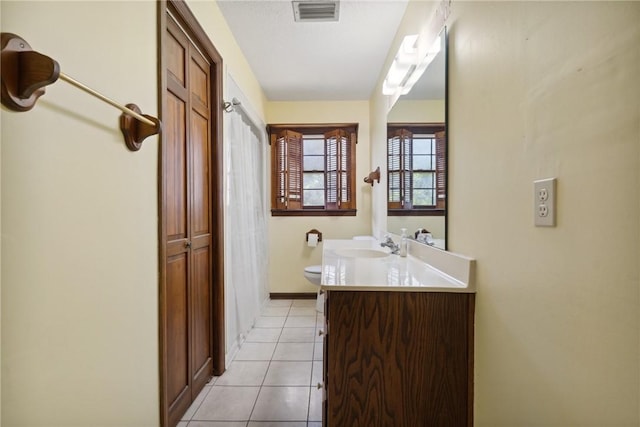 bathroom featuring tile patterned flooring, vanity, and toilet